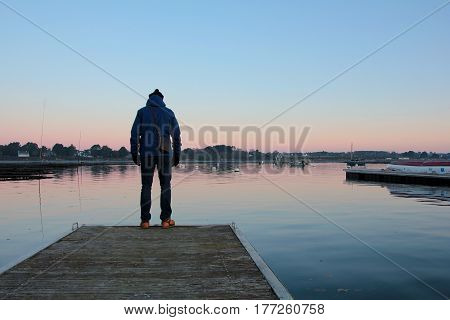 Man stands on the jetty of a french habor