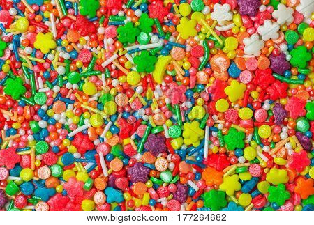 Sweet sugar spreading pastry decoration. Сlose view of colorful candy sprinkles.