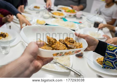Family gathering eating meal around kitchen table