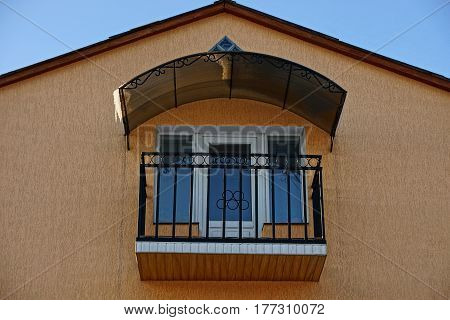 Facade of the building with a balcony and windows