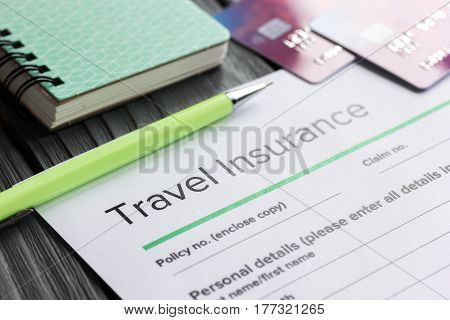 Traveling concept with insurance application form and credit cards on gray wooden table background
