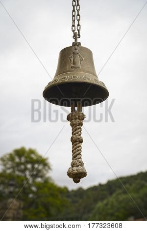 Yellowish metal bell with the image of our Lady