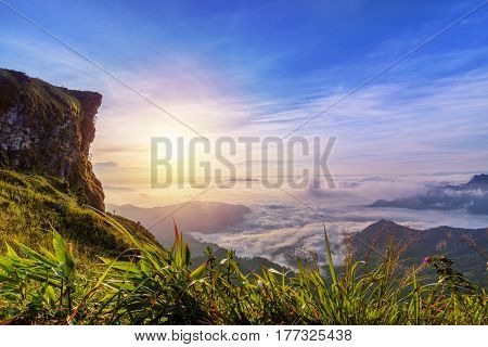 Beautiful landscape nature of sunrise on peak mountain with sun cloud fog and bright colors of sky in winter at Phu Chi Fa Forest Park is a famous tourist attraction of Chiang Rai Province Thailand