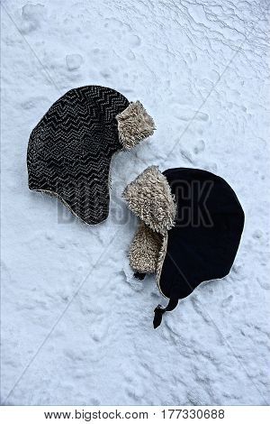 Winter hats with earflaps in the snow