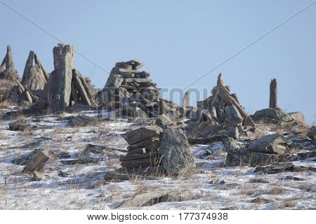 Stone pyramids for spirits on Ogoi island. Winter landscape