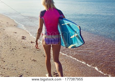 Surfer girl on the beach waiting for waves