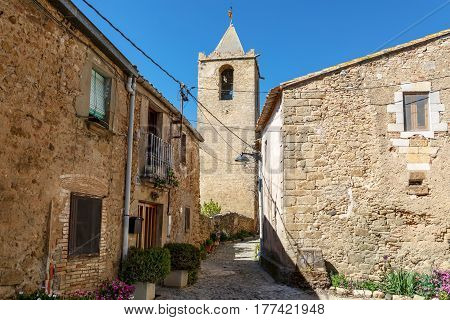 View of the medieval stone houses of the 16th century and bell tower Eglesia de Sant Esteve of 12th century. Village Sant-Esteve-de-Guialbes San Esteban de Guialbes, province Girona, Spain