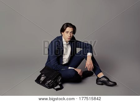 Business fashion man wearing blue suit with white shirt. Studio shot against grey. Processed with VSCO s3 preset