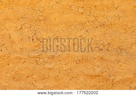 Cracked wall with broken clay plaster. Vintage surface texture. Rought painted wall texture.