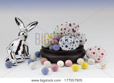 Easter egg background with silver rabbits and speckled easter eggs on white