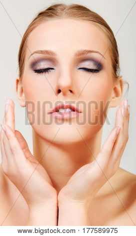 Attractive blonde topless woman with dark eye make up