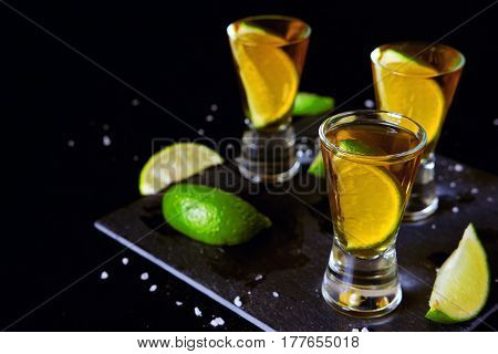 Strong alcohol drinks. Tequila glass shots in the bar with salt and lime slices.