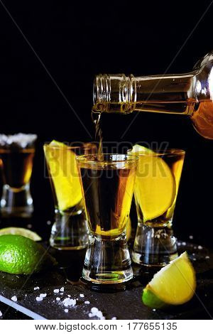 Strong alcohol drinks. Tequila glass shots in the bar with salt and lime slices.