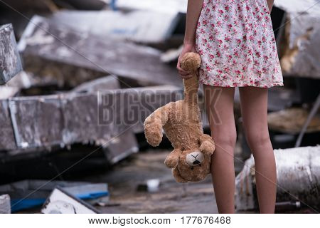 Photo of Sad woman standing and holding bear doll in her hand