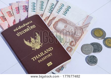 Thailand passport with isolated white background baht banknotes and coins
