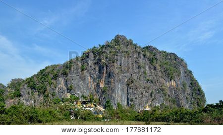 Panoramic view of the Bayin Nyi Cave complex in Hpa-An Myanmar. Buddhist monastery temple and lots of golden payas located near the foot of the big mountain.