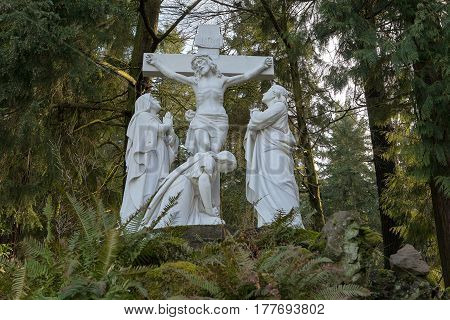 Jesus Christ nailed to the cross with Mother Mary marble statue at The Grotto Catholic National Sanctuary in Portland Oregon