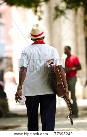 Cuban man wearing traditional panama straw hat playing an acoustic guitar. Taken in Trinidad, Cuba