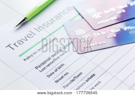 Traveling concept with insurance application form and credit cards on white table background