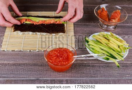 Woman Making At Home Japanese Sushi Rolls.