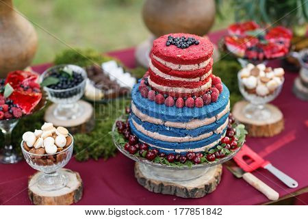 Wedding cake with berries, Blueberries and raspberriess on the table. Fourchette, a lot of food on the table