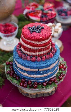 Wedding cake with berries, Blueberries and raspberriess on the table. Fourchette, a lot of food on the table