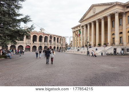 Tourists Walking Around The Piazza Bra Square And Take Pictures