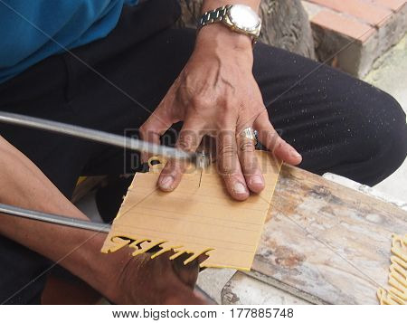 The master cuts a fret saw templates for production of souvenirs