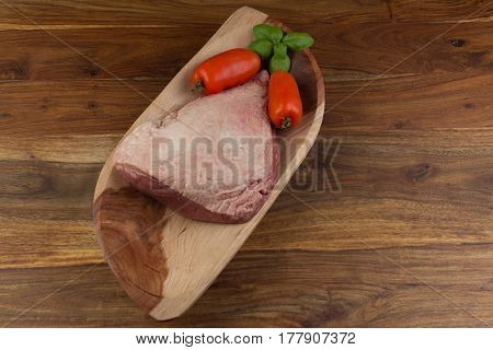 Top View Of A Full Piece Of Raw Cow Beef (picanha), Tomatoes And Basil On A Wood Rectangular Bow And