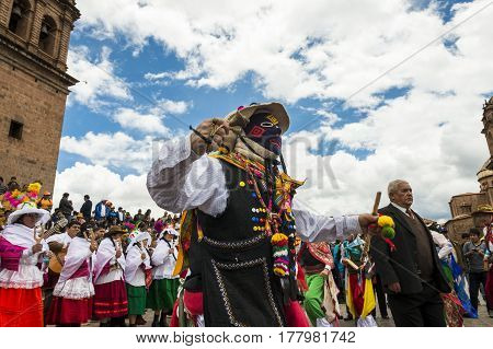 Cuzco Peru - December 25 2013: Man wearing traditional clothes and masks dancing the Huaylia in the Christmas day in front of the Cuzco Cathedral in Cuzco Peru.