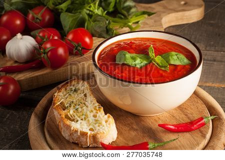 Fresh, Healthy Tomato Soup With Basil, Pepper, Garlic, Tomatoes And Bread On Wooden Background. Span