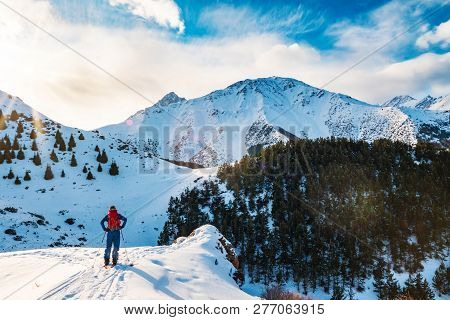 A Man In The Mountains. Ski Touring On A Split Snowboard. A Man Stands With His Back To The Viewer A