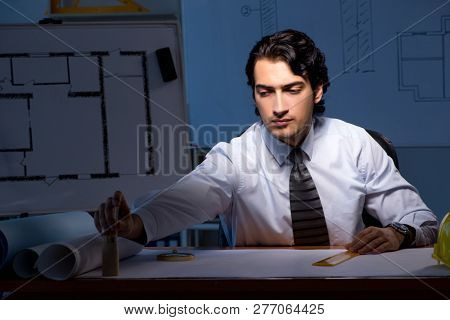 Young construction architect working on project at night 