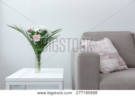 Couch With Pillow Next To Table Of Flowers Modern Living Room Decor Against White Background