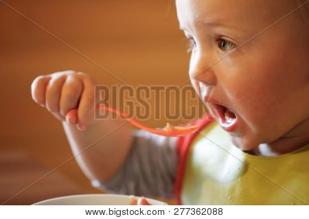 Child Eating Independently With A Spoon