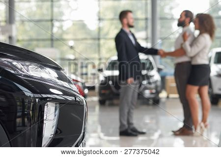 Auto Headlight Close Up. Woman Standing Near Husband And Opposite To Manager Of Car Center. Couple P