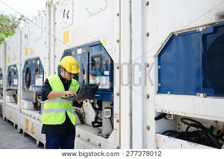 Asian Man Reefer Technician Is Seriously Working And Monitoring Reefer Container At The Port.