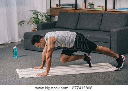 Bi-racial Man Training On Fitness Mat In Sportswear