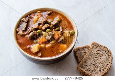 Tasty Hungarian Hot Goulash Soup Bograch Or Gulas Lamb Meat Stew With Whole Grain Bread On Wooden Su