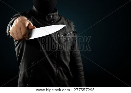 The Serial Killer, A Maniac With A Knife And A Black Chuolkom On His Head. Halloween Concept, Psycho