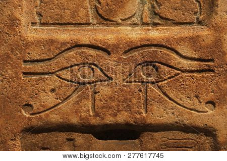 Close Up Background Of Antique Stone Wall With Carved Ancient Egyptian Bas Relief Of Wadjet, Eye Of 