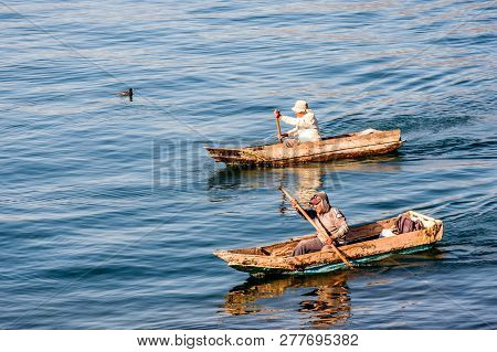 Panajachel, Lake Atitlan, Guatemala - December 23, 2018: Two Men Paddle In Dugout Canoes In Early Mo