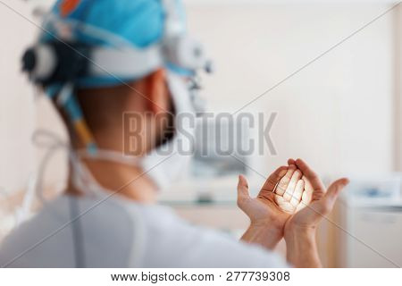 Doctor Surgeon In Medical Mask In Professional Magnifying Glasses Shines On His Hand With A Flashlig