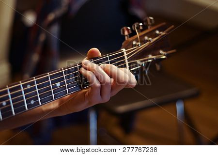 Man Playing Guitar And Holding A Chord