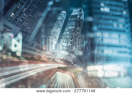 Hong Kong Business District At Night With Light Trails On The Street Movement.