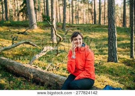 Young Adult Beautiful Caucasian Girl Woman Dressed In Red Jacket Resting Sitting On Fallen Tree And 