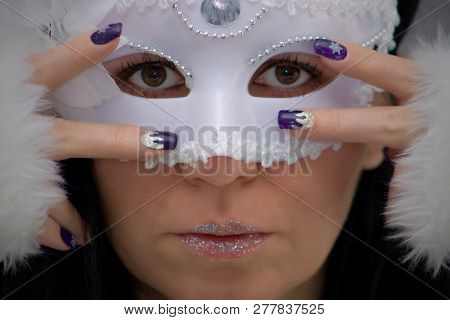 The Woman Has Beautiful Eyes, White Carnival Mask And Blue Gold Nails With Snowflakes.caucasian Woma