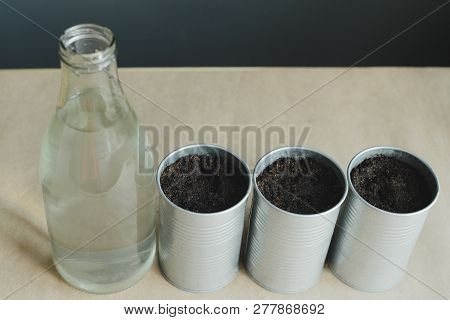 Still Life Of Glass Bottle And Metal Pot With Soil To Planting Greens, Stock Photo Image