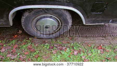 Opotřebované pneumatiky s trávy a bláta