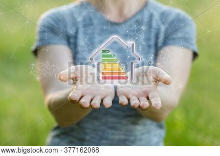Energy Efficient Home Concept. A Woman Shows A Model Of An Energy-saving House.